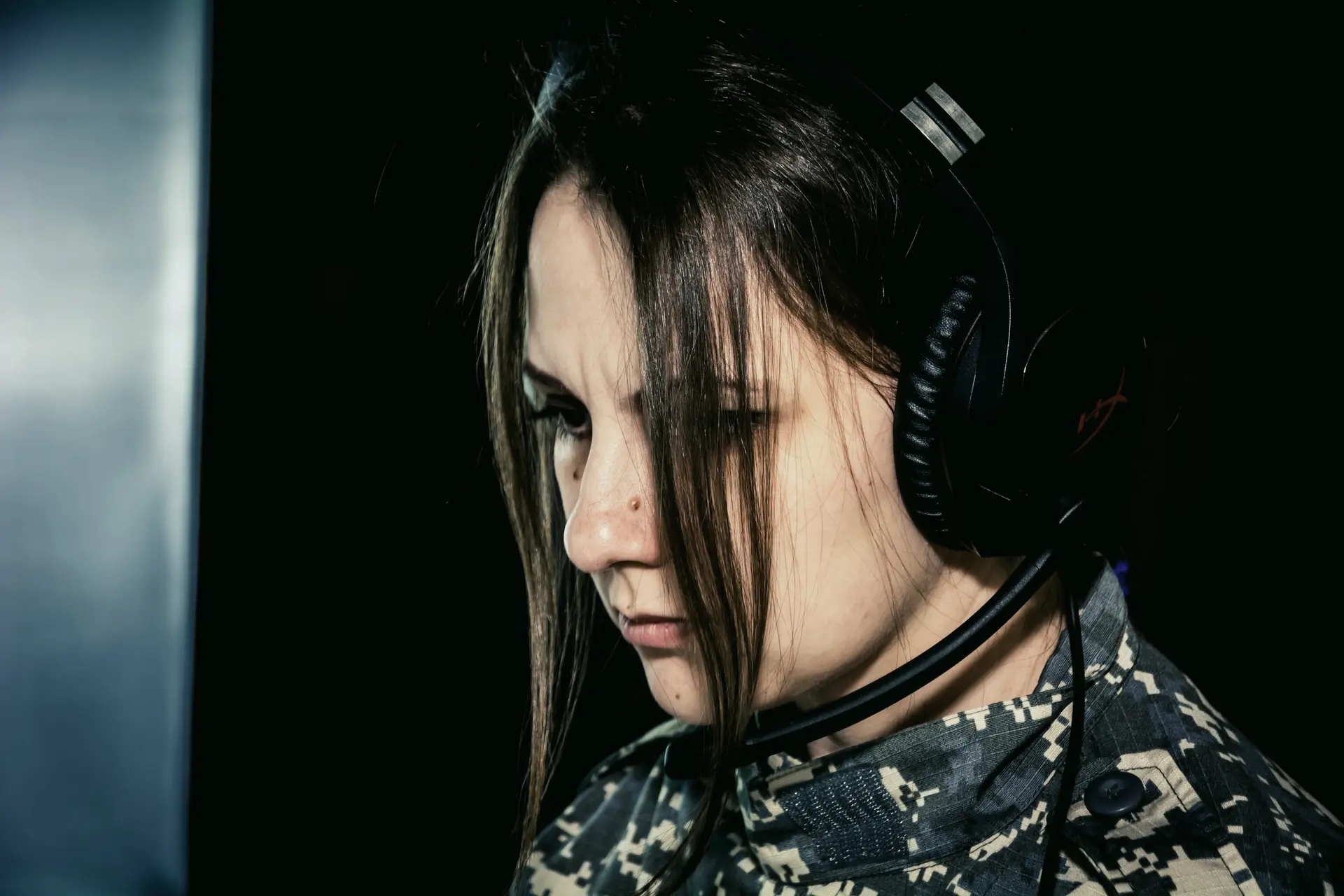 A service member wearing a headset at a workstation
